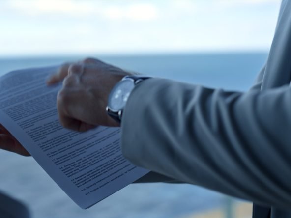 Partners discussing contract details at sea view. Closeup hand pointing papers